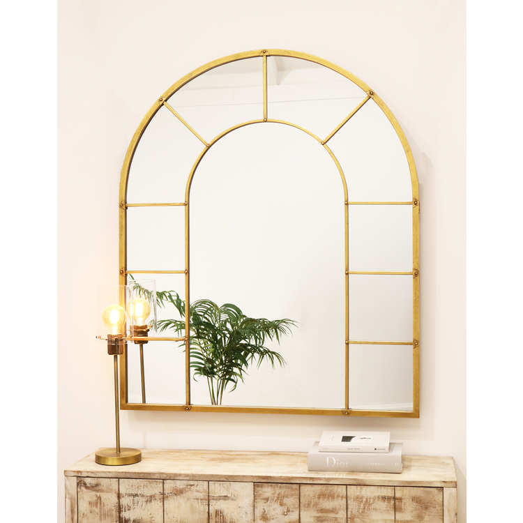 Gold industrial arched full length metal mirror on wall