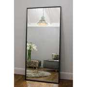Full Length Black Industrial Metal Mirror reflecting light in living room