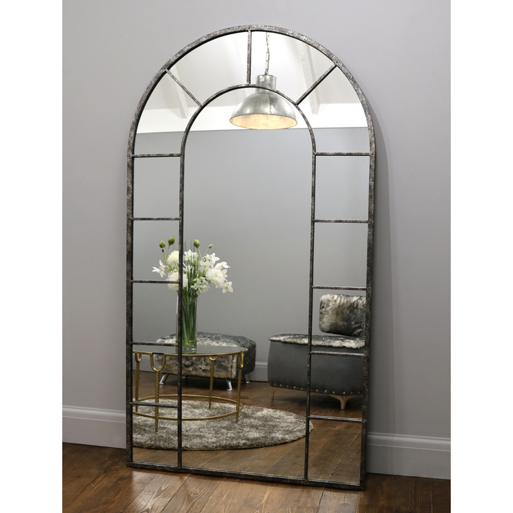 Crushed black industrial arched full length metal mirror with lounge in reflection