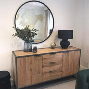 Black Metal Modern Round Wall Mirror on wall amonst vases