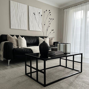 Black modern large rectangle tinted mirrored coffee table adorned with decorations